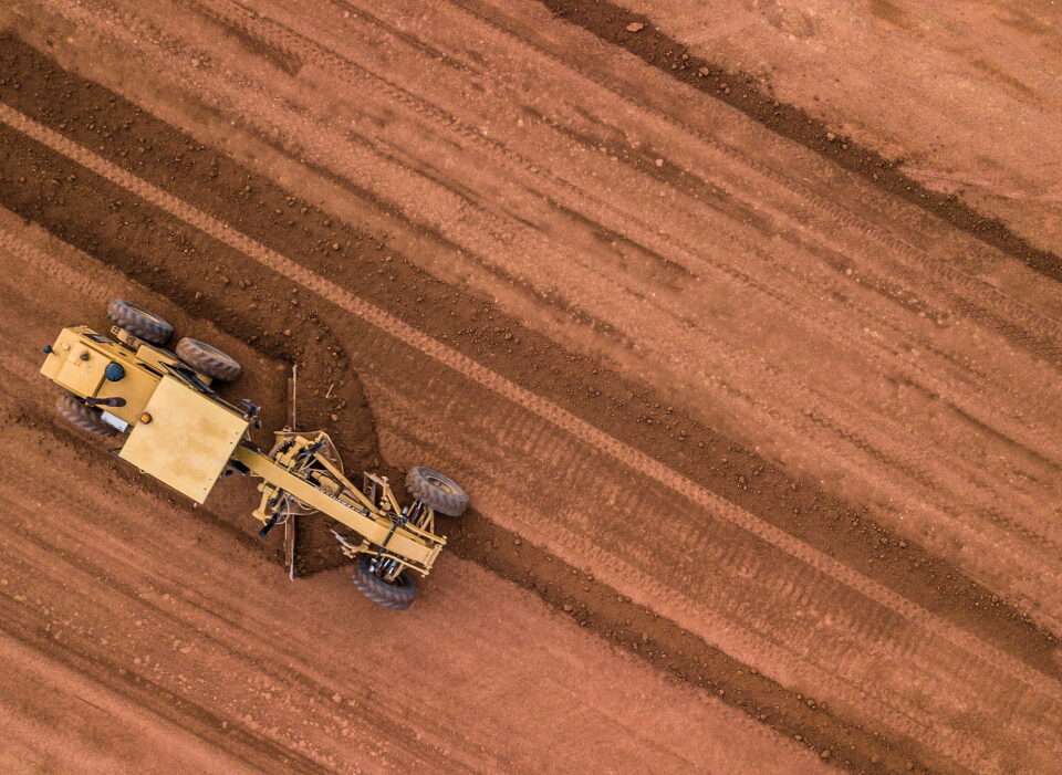 Aerial top view road roller and loader excavator tractor and soil grade car earthmoving at work.